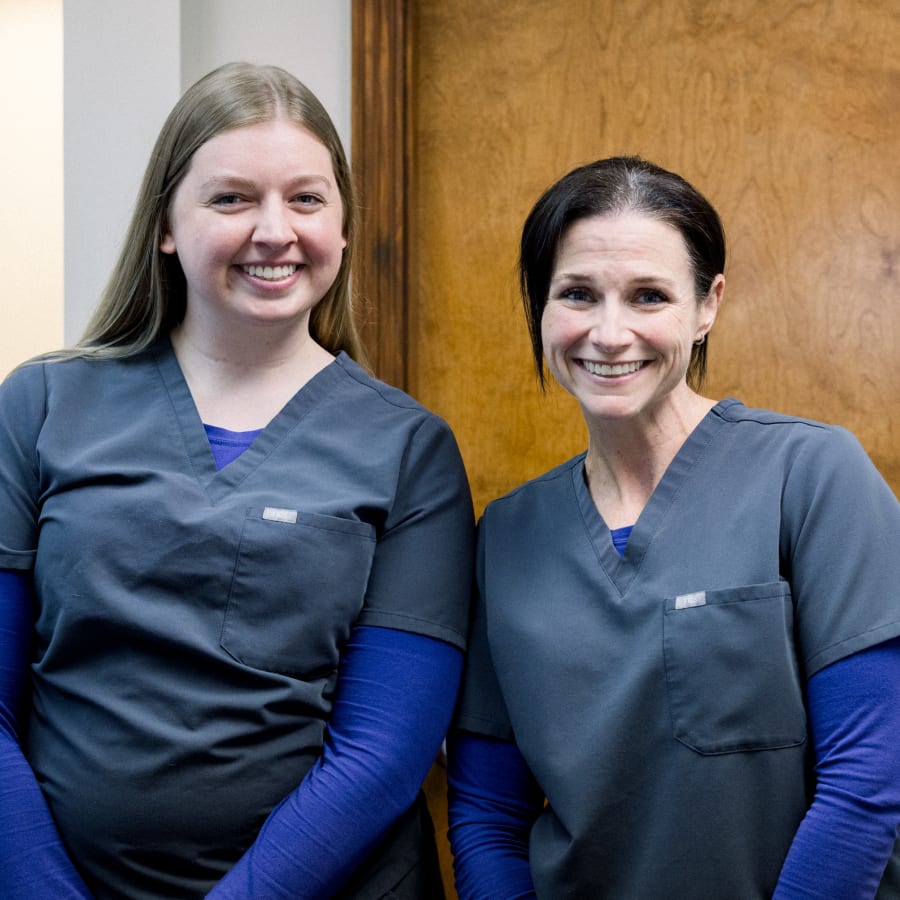 Two dental professionals are smiling for the camera.