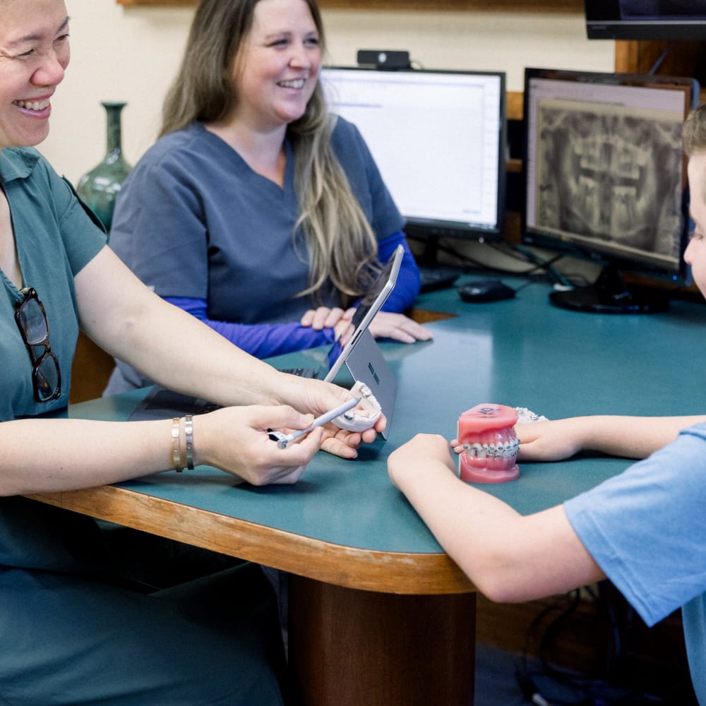 Dr. Diane points to a model of teeth with braces.