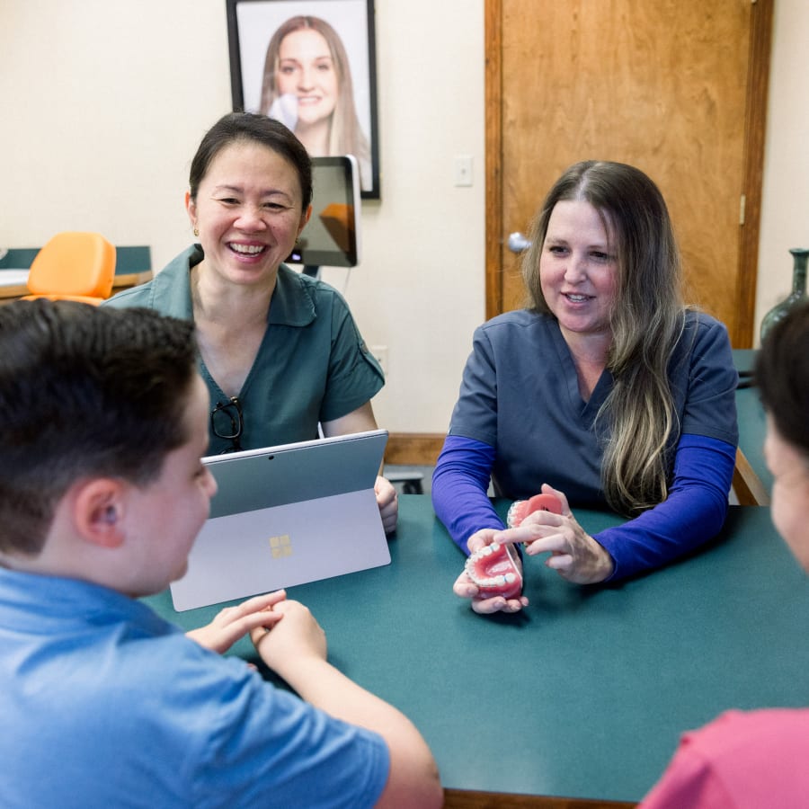 Dr. Diane and one of her team members are showing patients models of braces.
