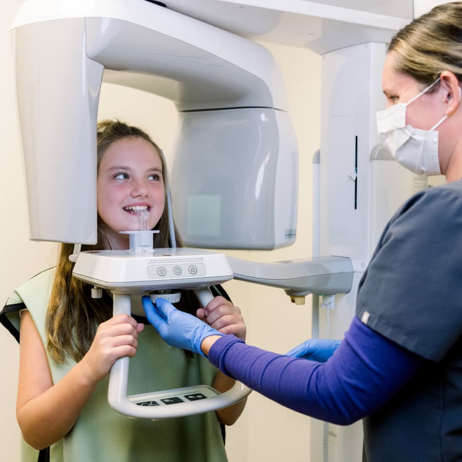 A young patient is about to have a panoramic X-ray taken.